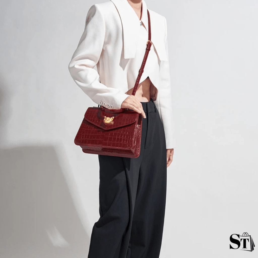 Jeune femme portant un sac à main à motif crocodile rouge avec décorations dorées pour les businesswomen