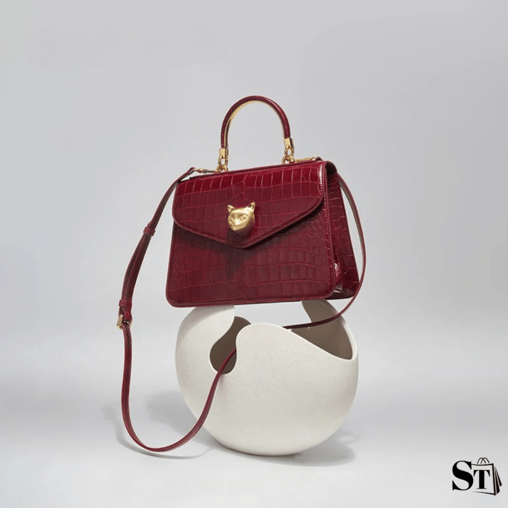 sac à main rouge à motif peau de crocodile de luxe pour femmes businesswomen posé sur son présentoir