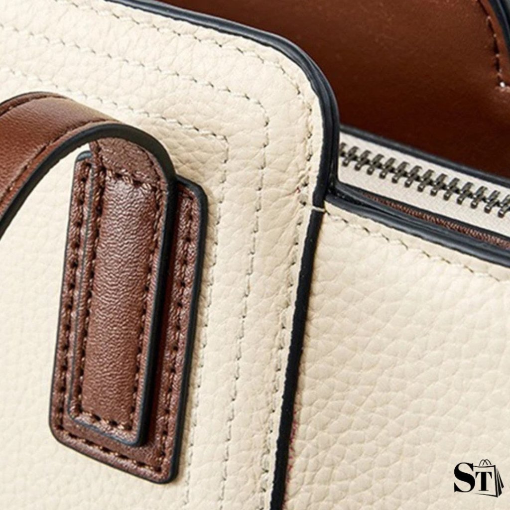 Détail de couture et attache de l’anse du sac cabas Le Solène en cuir grainé.