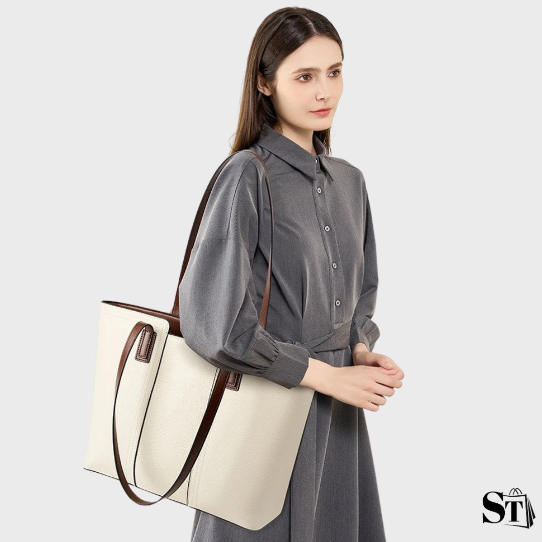 Le sac cabas Le Solène porté à l’épaule par une femme en robe chemise grise.