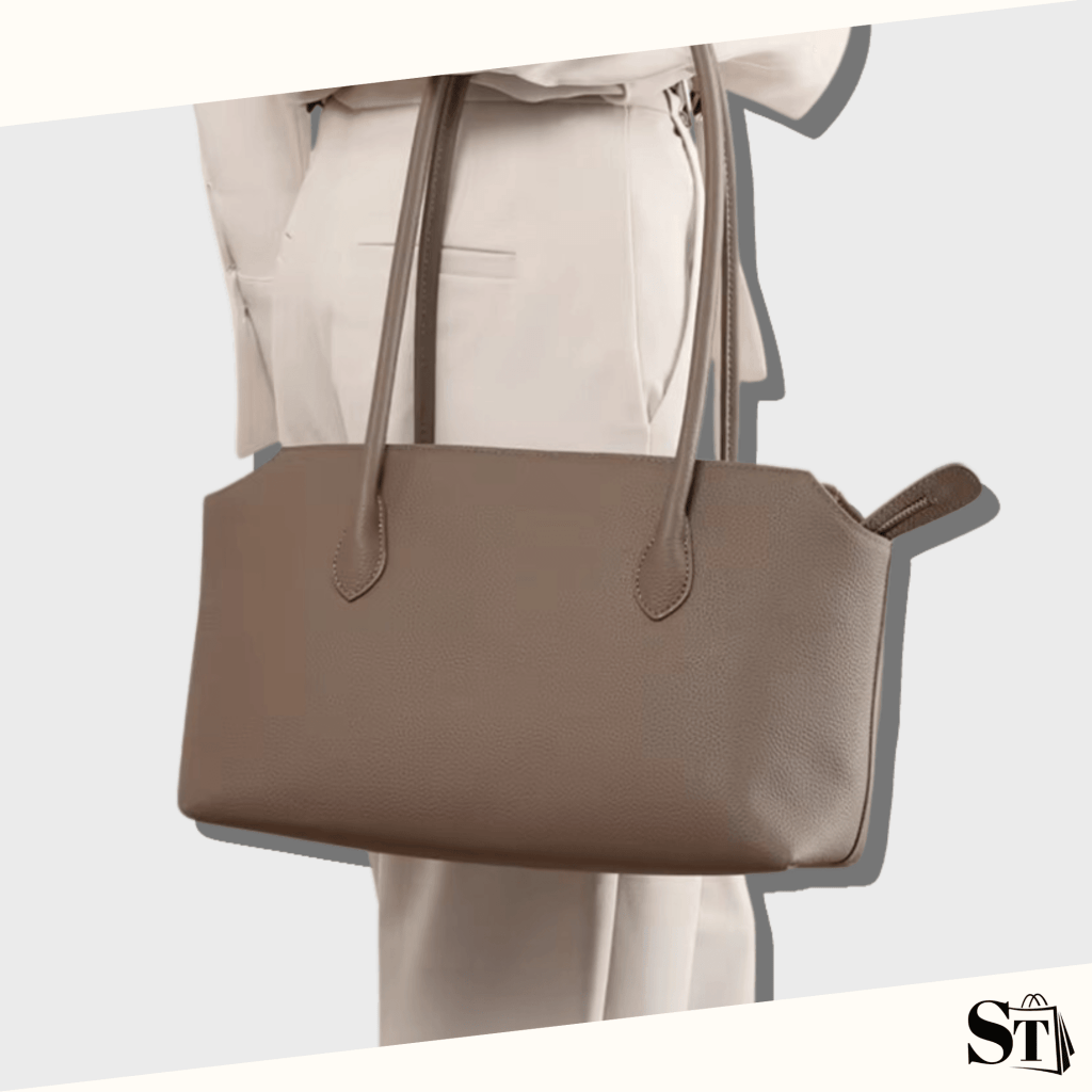 Jeune femme portant un sac d'épaule en cuir gris à la main