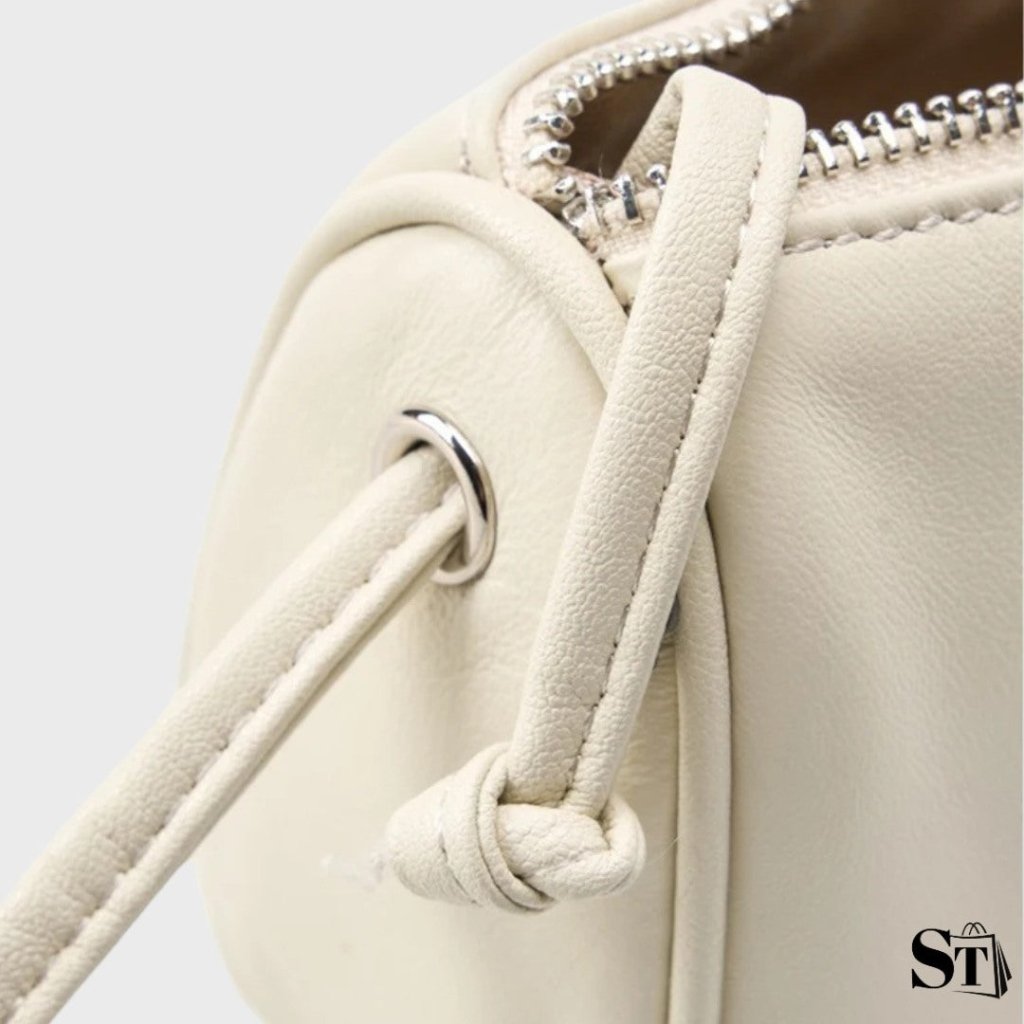 Détail du sac Cocon en cuir blanc – focus sur la bandoulière, la couture et l’anneau métal