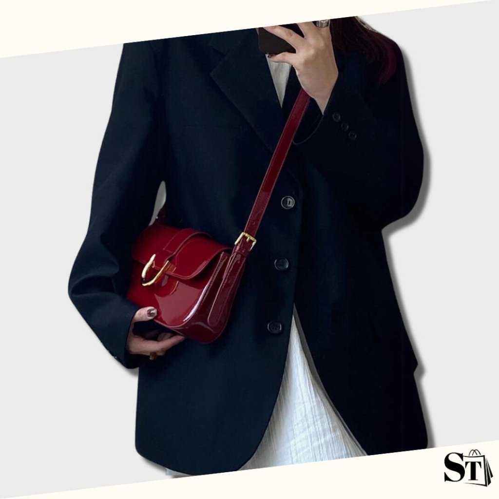 jeune femme habillée classique portant un magnifique sac baguette de couleur bordeaux verni