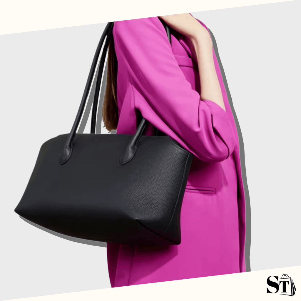 Jeune femme habillée en tenue chic rose bonbon, portant un sac à épaule en cuir noir de qualité StylishStrap