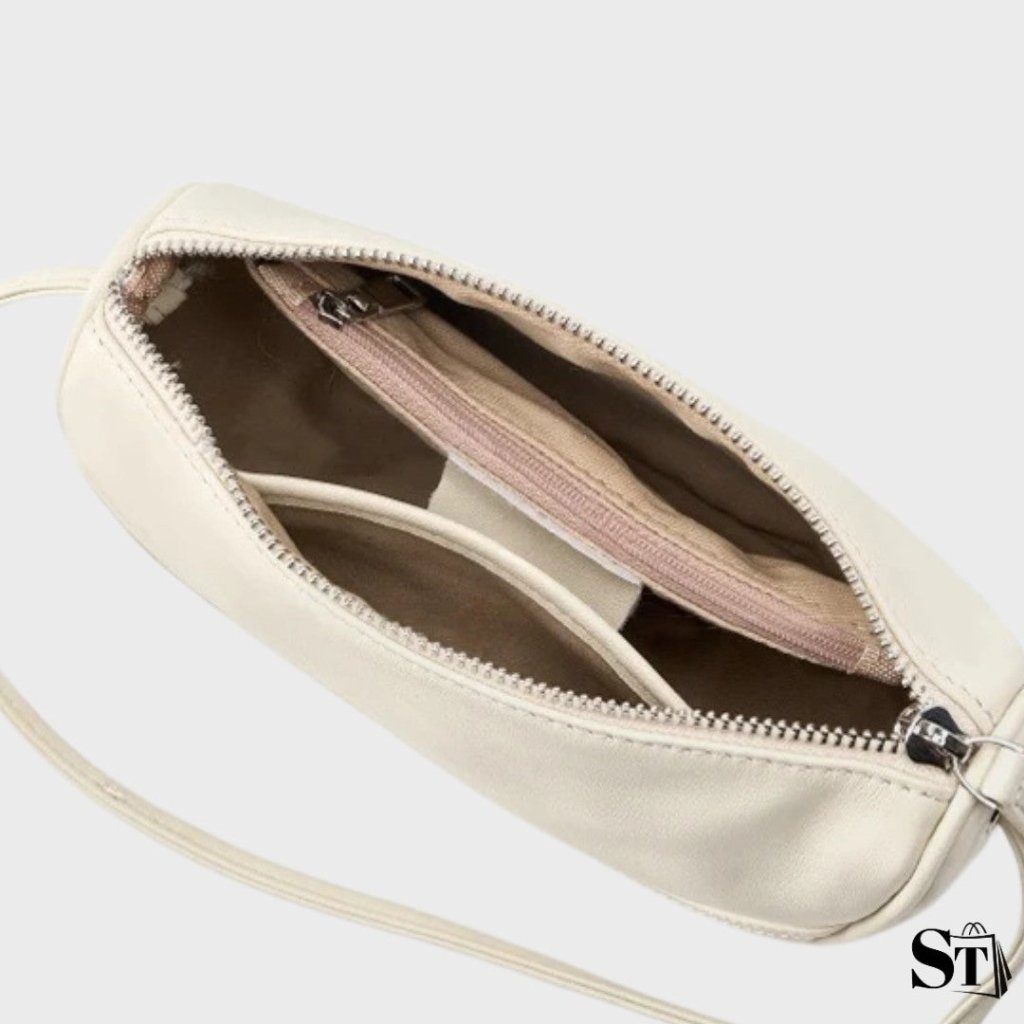 Vue intérieure du sac Cocon en cuir blanc cassé – poches zippées et compartiments de rangement